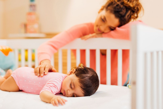 Mom rubbing back of baby during sleep training