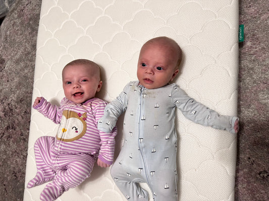 babies laying on crib mattress