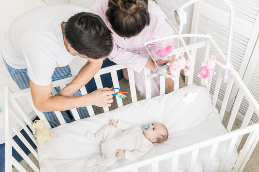 Parents follwing baby sleep temperature guidelines while putting baby in crib