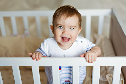 baby in crib with crib bumbers