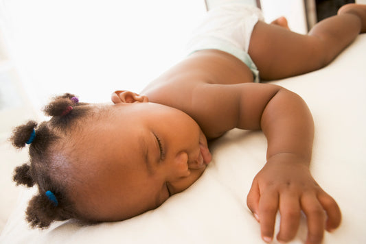 baby sleeping on crib mattress pad