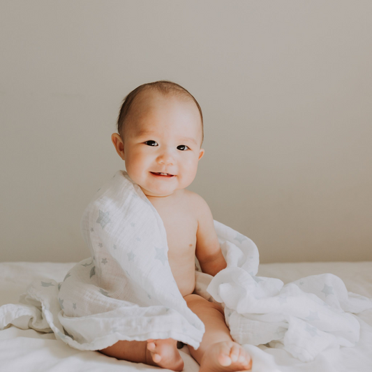 Baby wrapped in organic crib sheet